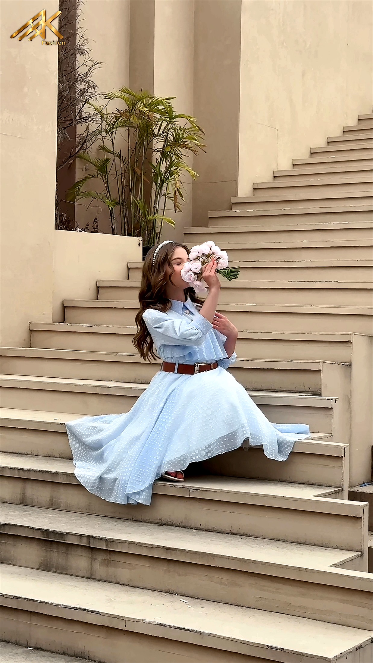 Girl wearing an AK Fashion light blue dress with brown leather belt