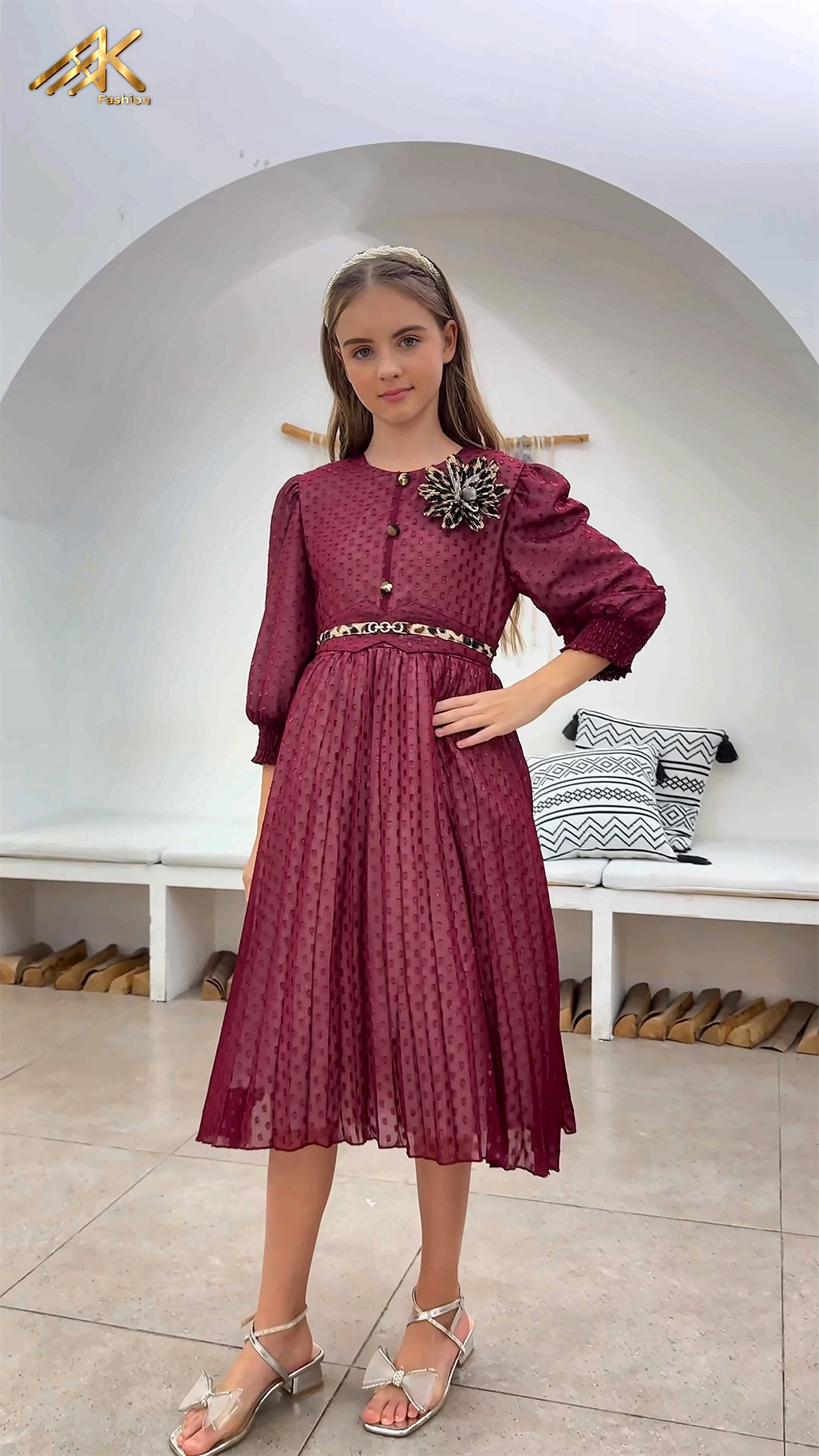 Maroon dress with leopard-print belt accent and brooch