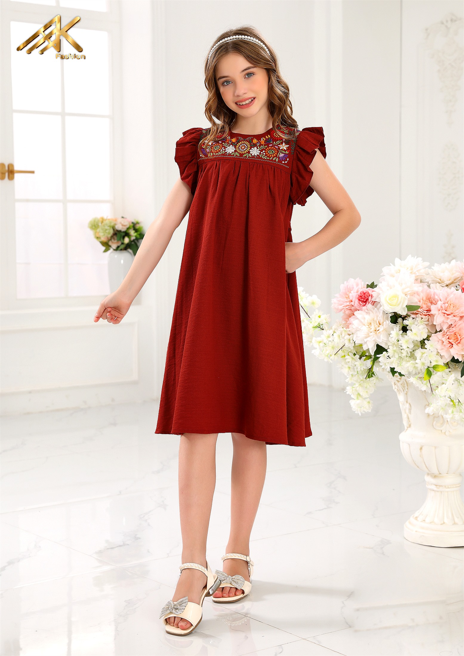 Girl wearing an AK Fashion burgundy dress with floral embroidery